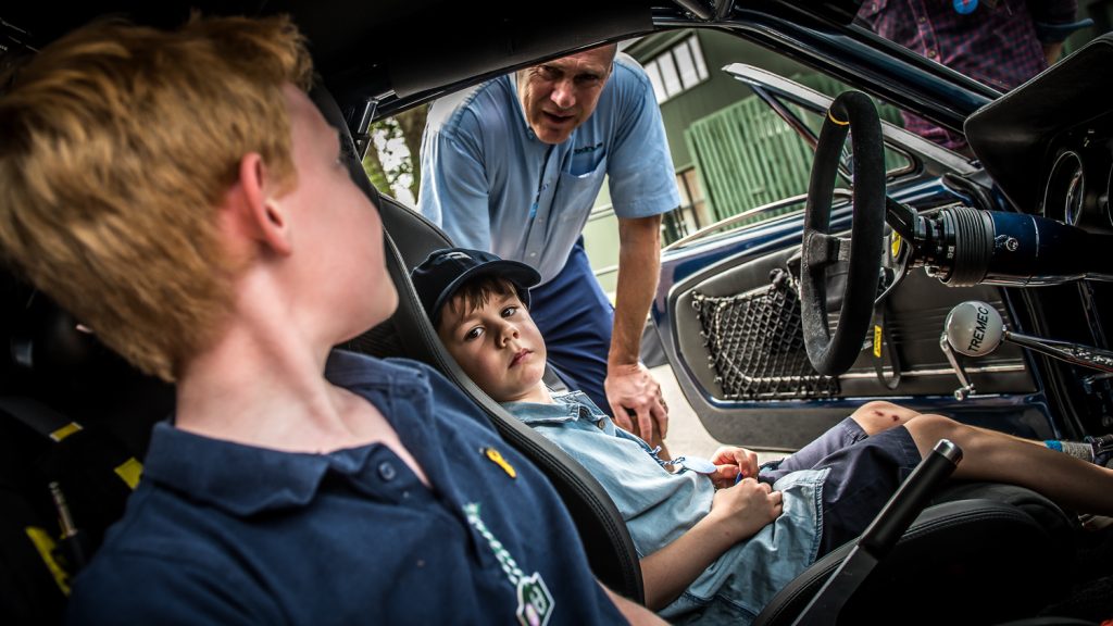 engineer shows 2 boys inside rally car