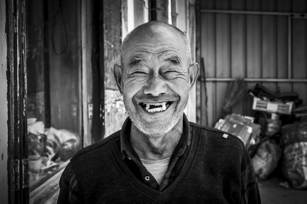 smiling toothless man in chinese village