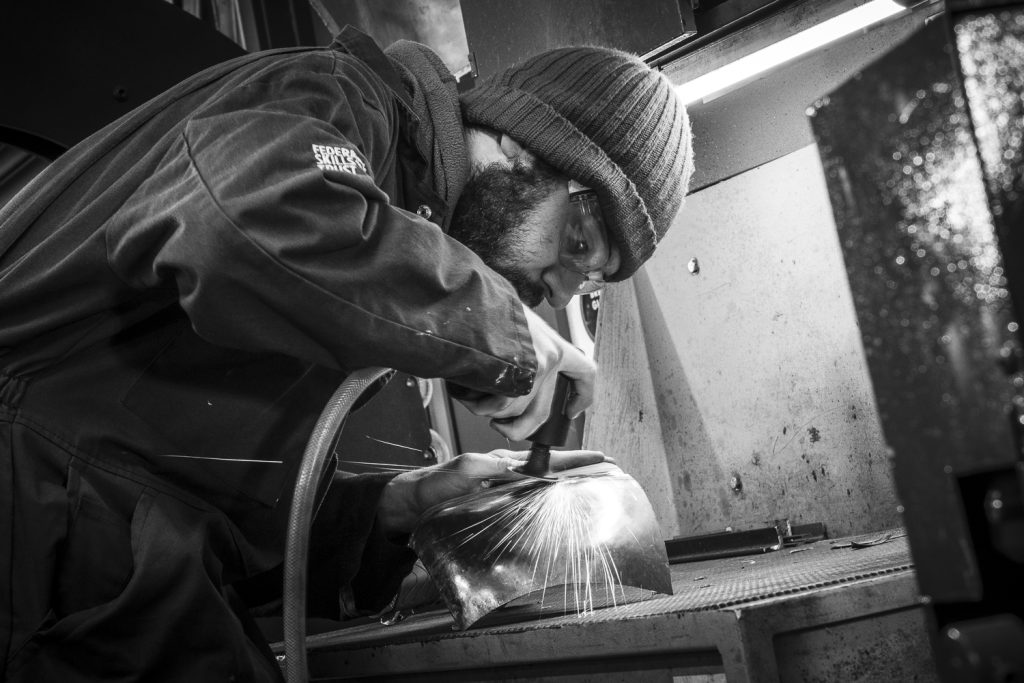man grinding weld sparks